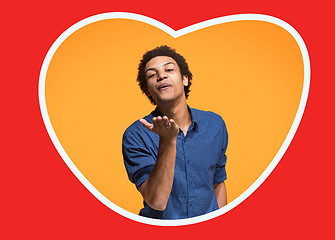 Image showing The happy business man standing and smiling against orange background.