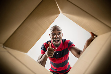 Image showing Man unpacking and opening carton box and looking inside