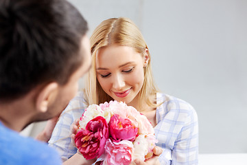 Image showing happy couple with flowers at home