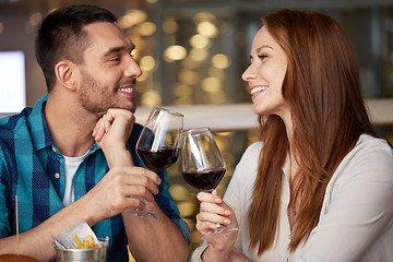 Image showing happy couple drinking red wine at restaurant