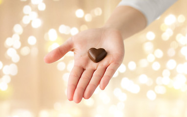 Image showing close up of hand with heart shaped chocolate candy