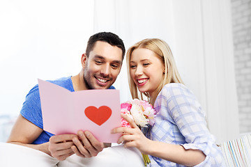 Image showing happy couple with greeting card and flowers