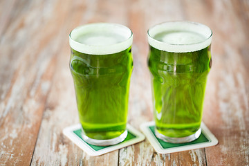 Image showing two glasses of green beer on wooden table