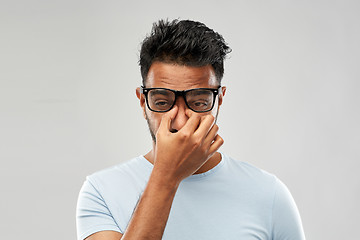 Image showing tired indian man in glasses rubbing nose bridge