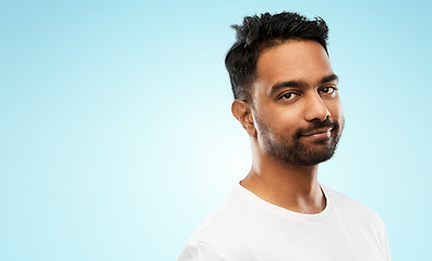 Image showing smiling young indian man over blue background