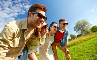 Image showing happy teenage friends laughing outdoors in summer