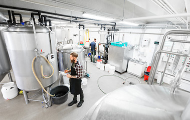 Image showing man with clipboard at craft brewery or beer plant