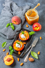 Image showing Fresh grilled peaches with honey and green basil.
