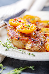 Image showing Juicy pork steak with apricots,thyme and potatoes.