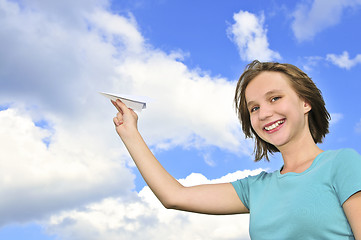 Image showing Young girl holding paper airplane