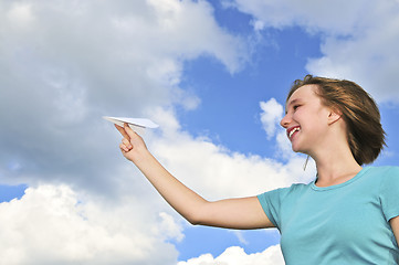 Image showing Young girl holding paper airplane