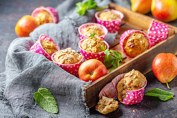 Image showing Muffins with pears and muesli in a wooden tray.