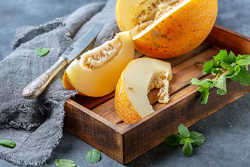 Image showing Slices of ripe yellow melon in a wooden tray.