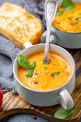 Image showing Tomato soup with cream, spices and green basil.