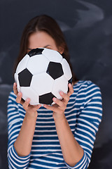 Image showing woman holding a soccer ball in front of chalk drawing board