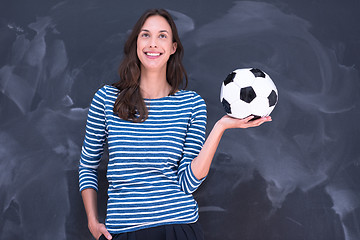 Image showing woman holding a soccer ball in front of chalk drawing board