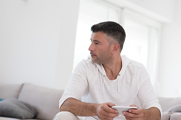 Image showing young man using a mobile phone  at home