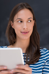 Image showing woman using tablet  in front of chalk drawing board