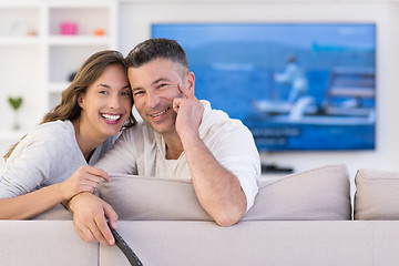 Image showing Young couple on the sofa watching television