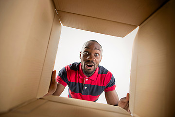 Image showing Man unpacking and opening carton box and looking inside