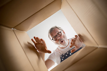 Image showing Man unpacking and opening carton box and looking inside