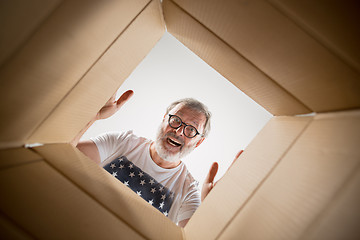 Image showing Man unpacking and opening carton box and looking inside