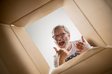 Image showing Man unpacking and opening carton box and looking inside