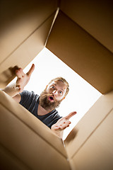 Image showing Man unpacking and opening carton box and looking inside