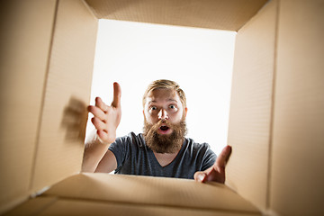 Image showing Man unpacking and opening carton box and looking inside