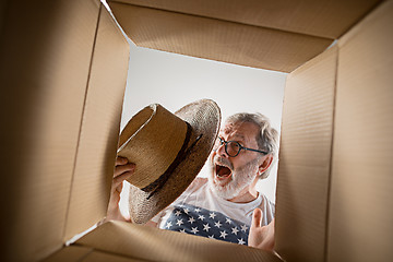 Image showing Man unpacking and opening carton box and looking inside