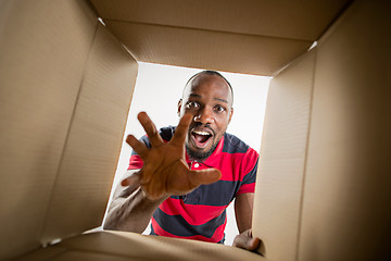 Image showing Man unpacking and opening carton box and looking inside