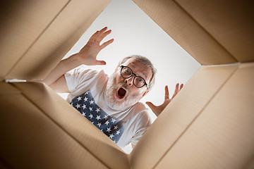 Image showing Man unpacking and opening carton box and looking inside