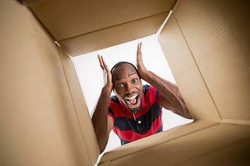 Image showing Man unpacking and opening carton box and looking inside