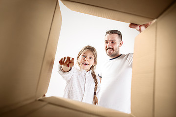 Image showing dad with daughter unpacking and opening carton box and looking inside