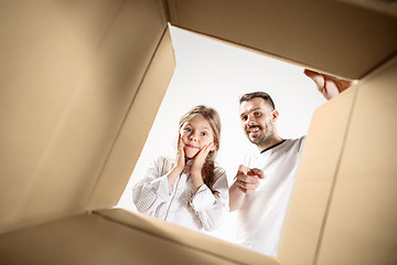 Image showing dad with daughter unpacking and opening carton box and looking inside