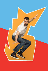 Image showing Freedom in moving. handsome young man jumping against orange background