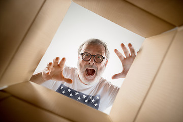 Image showing Man unpacking and opening carton box and looking inside