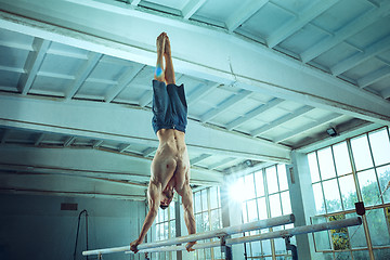 Image showing The sportsman during difficult exercise, sports gymnastics