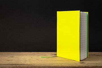 Image showing a yellow green note book on a wooden table