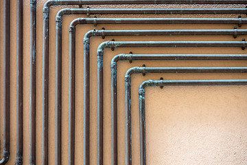 Image showing some copper tubes outside on a wall