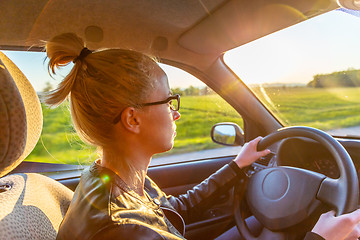 Image showing Casual caucasian woman driving passenger car for a journey in countryside.