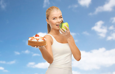 Image showing happy woman eating apple instead of cake