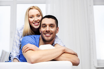 Image showing happy couple sitting on sofa and hugging at home