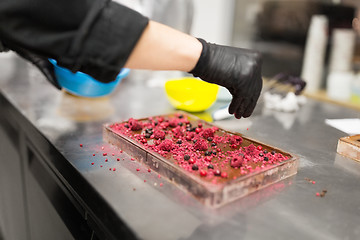 Image showing confectioner makes chocolate dessert at sweet-shop