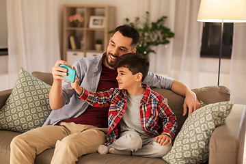 Image showing father and son taking selfie at home