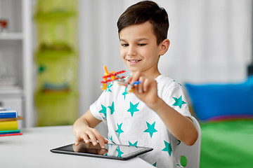 Image showing boy with tablet computer and toy airplane at home