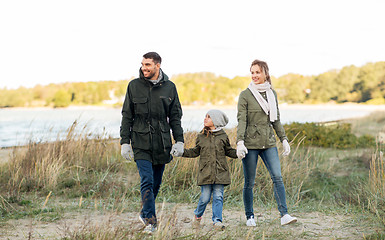 Image showing happy family walking along autumn beach