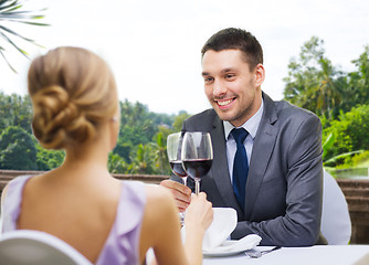 Image showing young couple with glasses of wine at restaurant