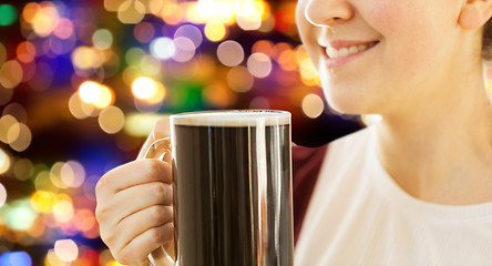 Image showing close up of smiling woman with dark beer in mug