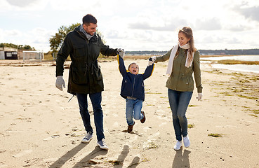 Image showing happy family walking along autumn beach